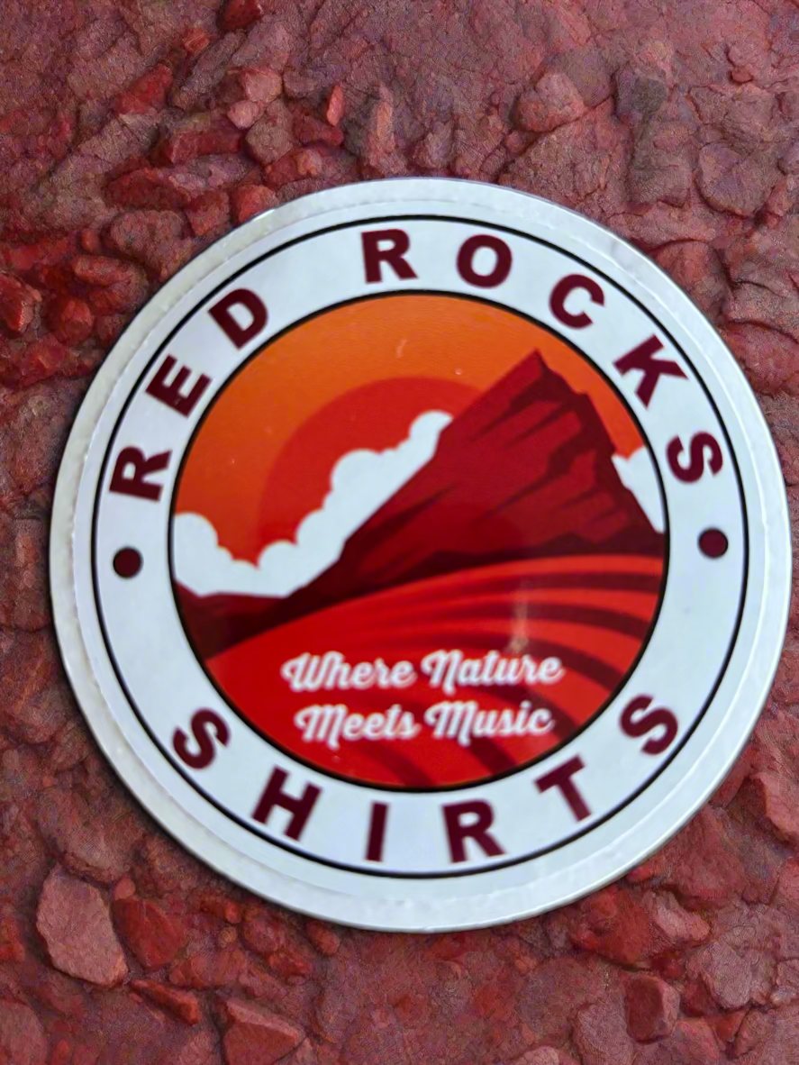 Round sticker with 'Red Rocks Shirts' design on a wooden surface